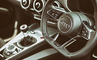 closeup photo of audi steering wheel with automatic shift gear lever