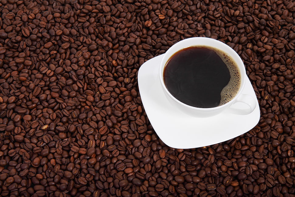 white ceramic cup on saucer on coffee beans HD wallpaper