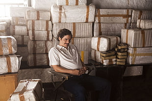 man wearing white polo shirt sitting near boxes HD wallpaper