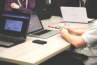 person sitting in front of a table using a MacBook Pro HD wallpaper