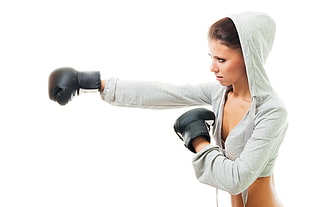 woman in gray hoodie with pair of black boxing gloves