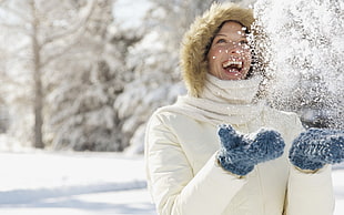 woman in white turtle-neck jacket playing snow