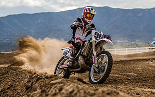 person riding motocross dirt bike on track during daytime