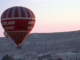 red and gray Hot Air Balloon flying on gray mountains during daytime, cappadocia