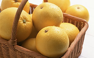 round yellow fruits inside wicker basket HD wallpaper