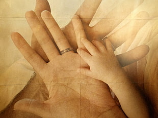 hands of mother, father, and baby
