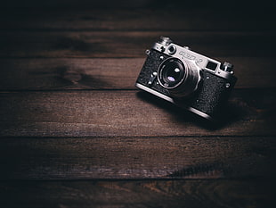 gray and black analog camera on brown wooden surface