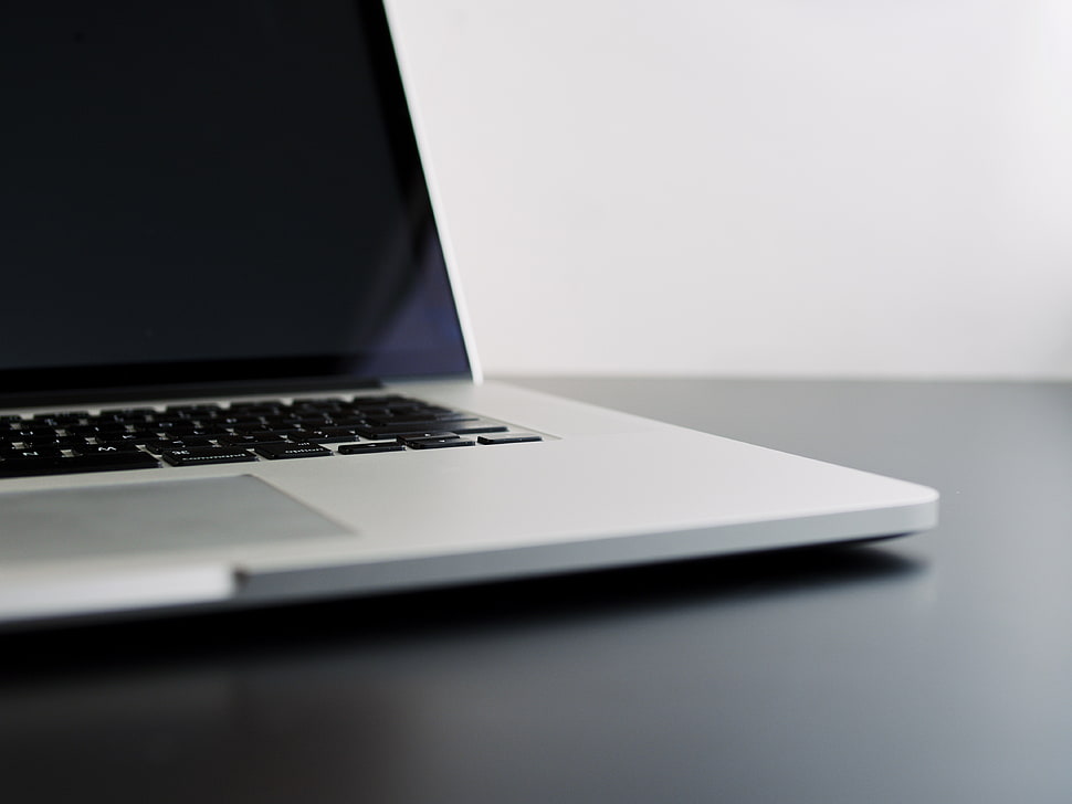 MacBook Pro on black wooden surface HD wallpaper