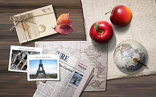 two red apples beside globe on textile HD wallpaper
