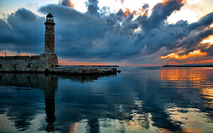 lighthouse underneath golden hour, lighthouse, water, photography, clouds