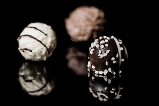 three round white-black-and-gray chocolate coated pastries