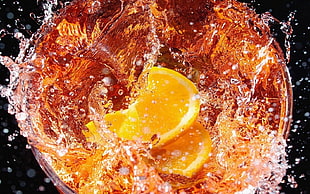 time lapsed photography of sliced lemon dropped on ice tea