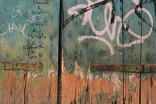 green and brown wooden wall, graffiti