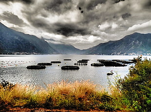panoramic photo of mountains near body of water under cloudy day