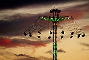 people riding green and brown Ferris wheel during sunset