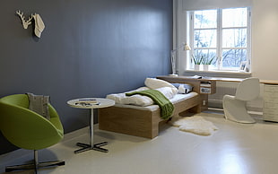 round white pedestal table beside green chair inside bedroom HD wallpaper