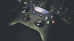 black Xbox One controller on black keyboard