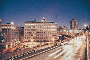 photo of concrete high-rise building near bridge
