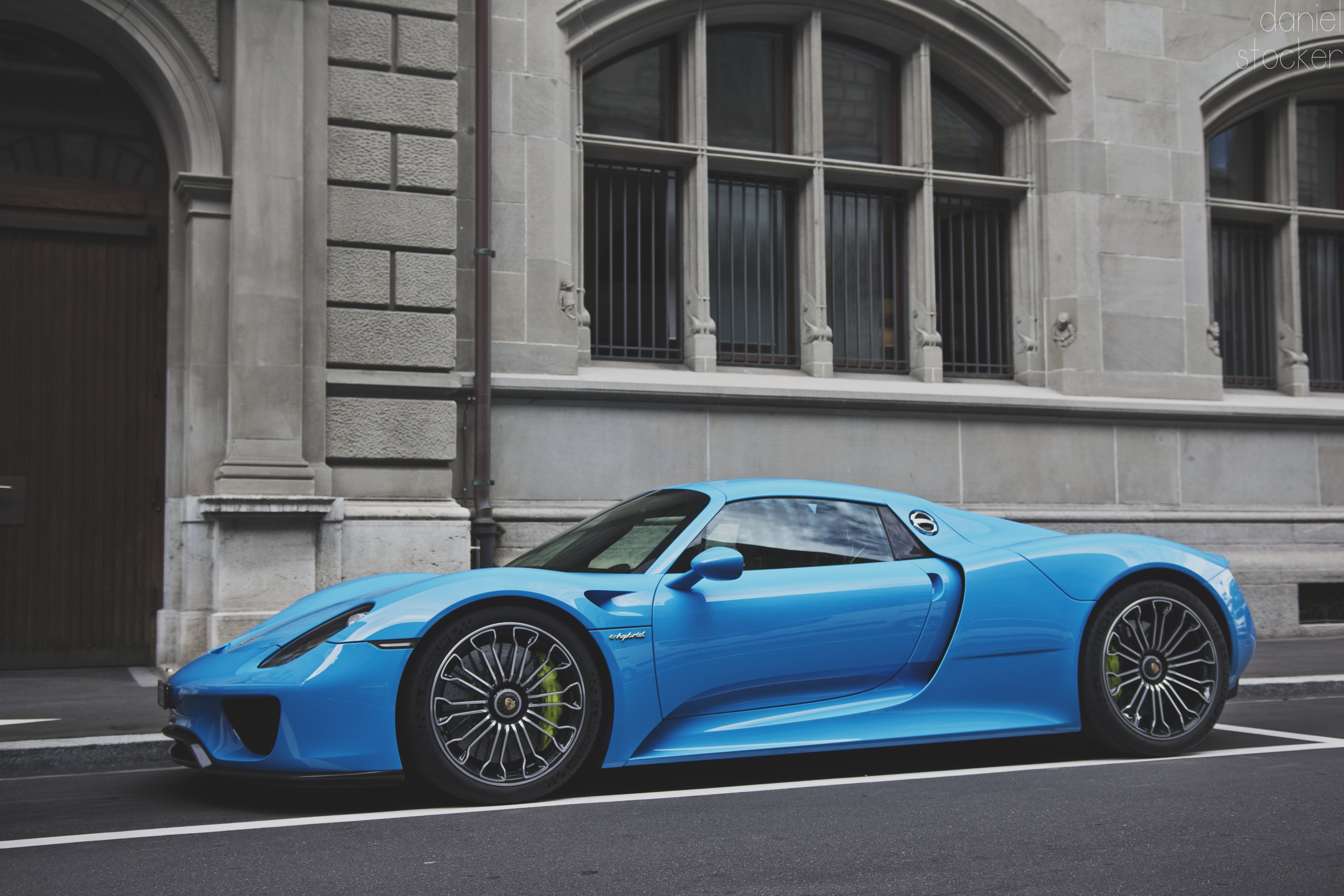 blue coupe beside gray concrete building