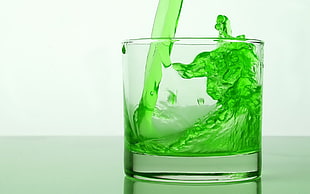clear shot glass with green liquid