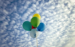 photography of balloons under cloudy sky during daytime