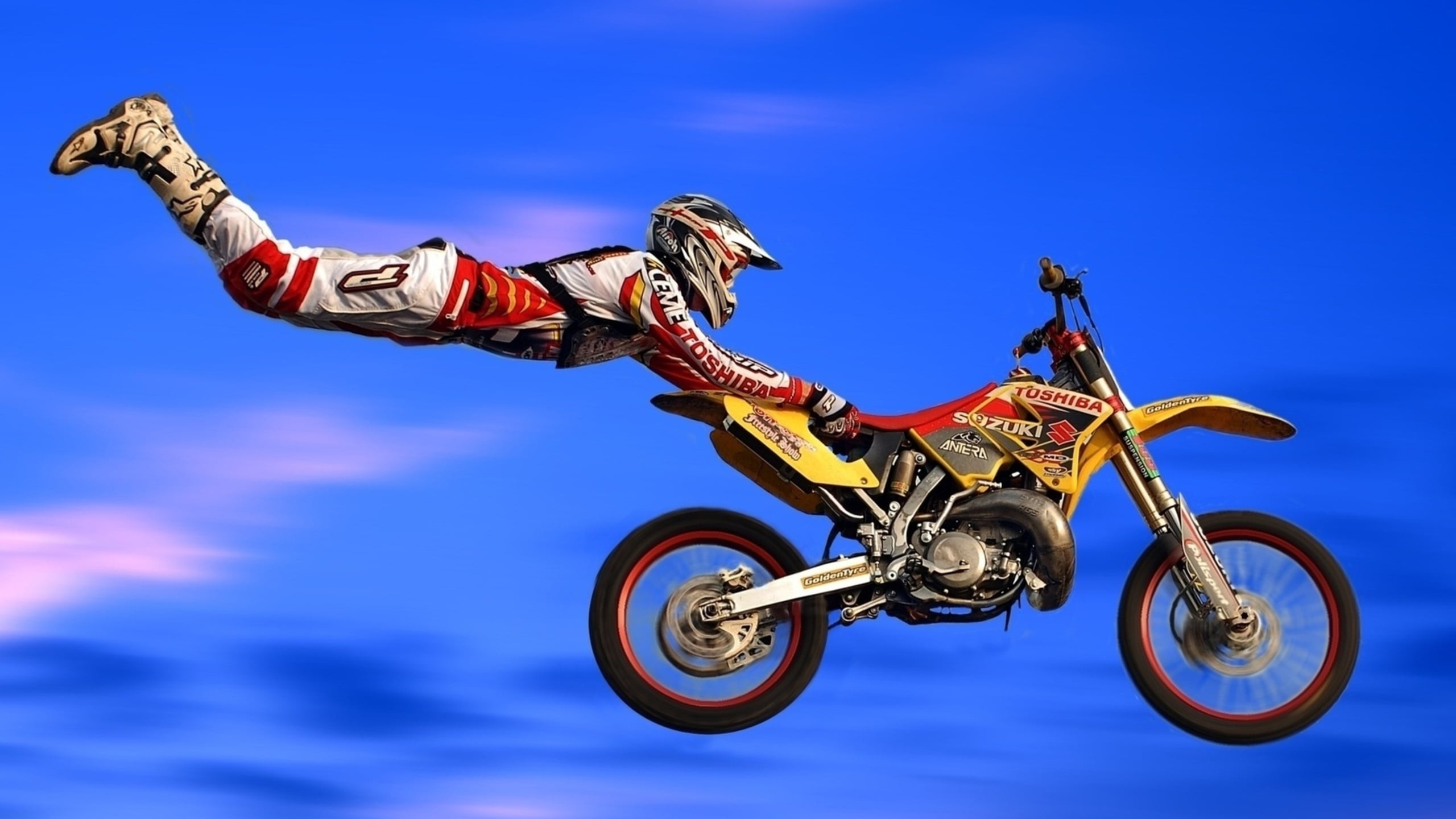 photo of person in motocross outfit doing dare devil motocross jump