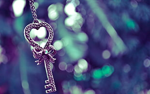 selective focus photography of skeleton key pendant