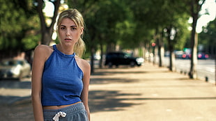 shallow focus photography of blonde haired woman in blue halter top