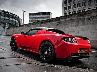 selective color photography of red Tesla Roadster