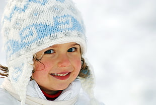 girl wearing white knit cap smiling facing camera