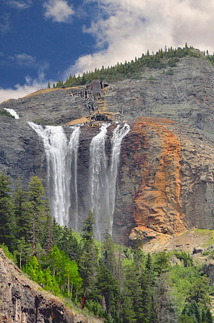 landscape photo of gray rocky mountain with waterfalls during daytome