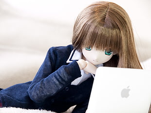 woman robot wearing blond hair and blue and white blazer looking on MacBook white while lying on bed HD wallpaper