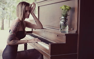 woman siting on chair while playing piano