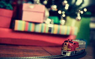 red and gray toy train on brown wooden surface