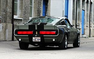 black Ford Mustang parked by the building