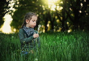 girl in grass field playing bubbles