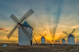 four white concrete windmills at during sunset