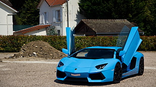 blue Lamborghini Aventador parked with doors opened during daytime