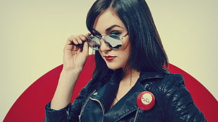 woman in leather jacket holding sunglasses