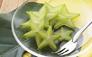 sliced carambola fruit on clear glass saucer