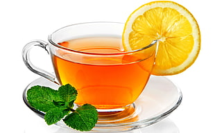 clear glass teacup filled with tea and sliced lemon