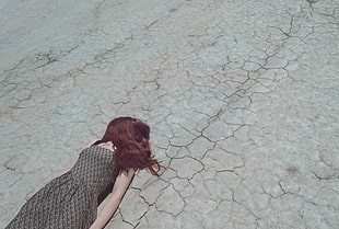 woman in brown dress lying on ground during daytime
