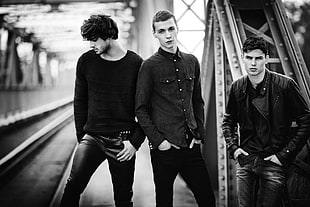 grayscale photo of three men in black long-sleeved shirts