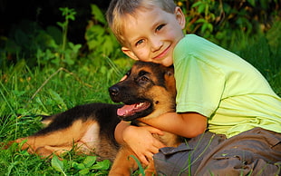 boy hugging German Shepherd puppy