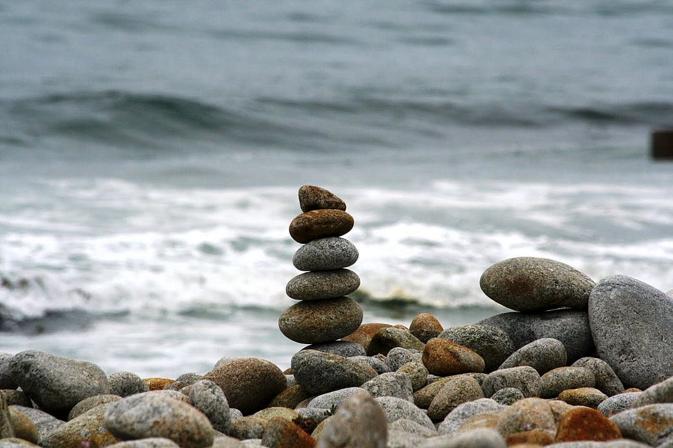 stacked stones with body of water in the background HD wallpaper