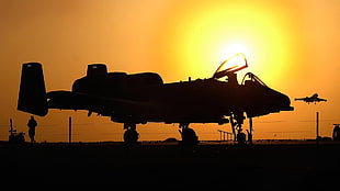 silhouette of fighter plane during dawn