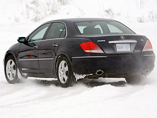 black Acura RL on snow field during daytime