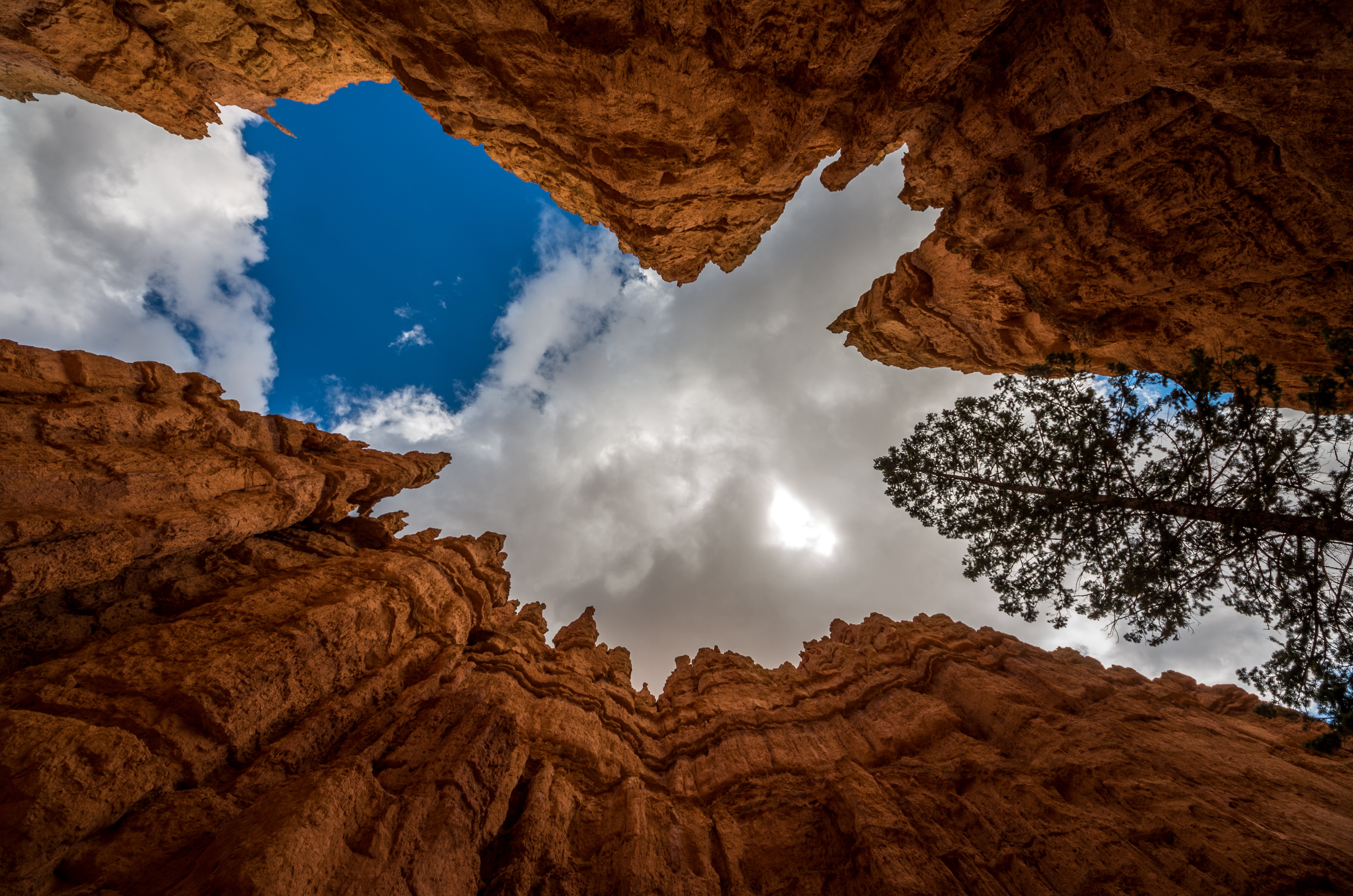 low angle photo of rugged cliff with cloudy sky during daytime, bryce canyon, usa