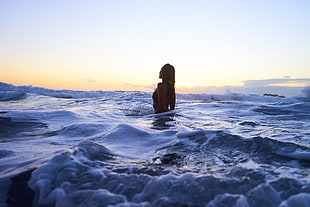 woman in black swinsuit on standing on sea