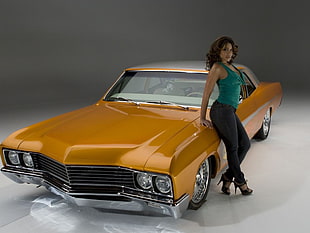 woman leaning on yellow coupe